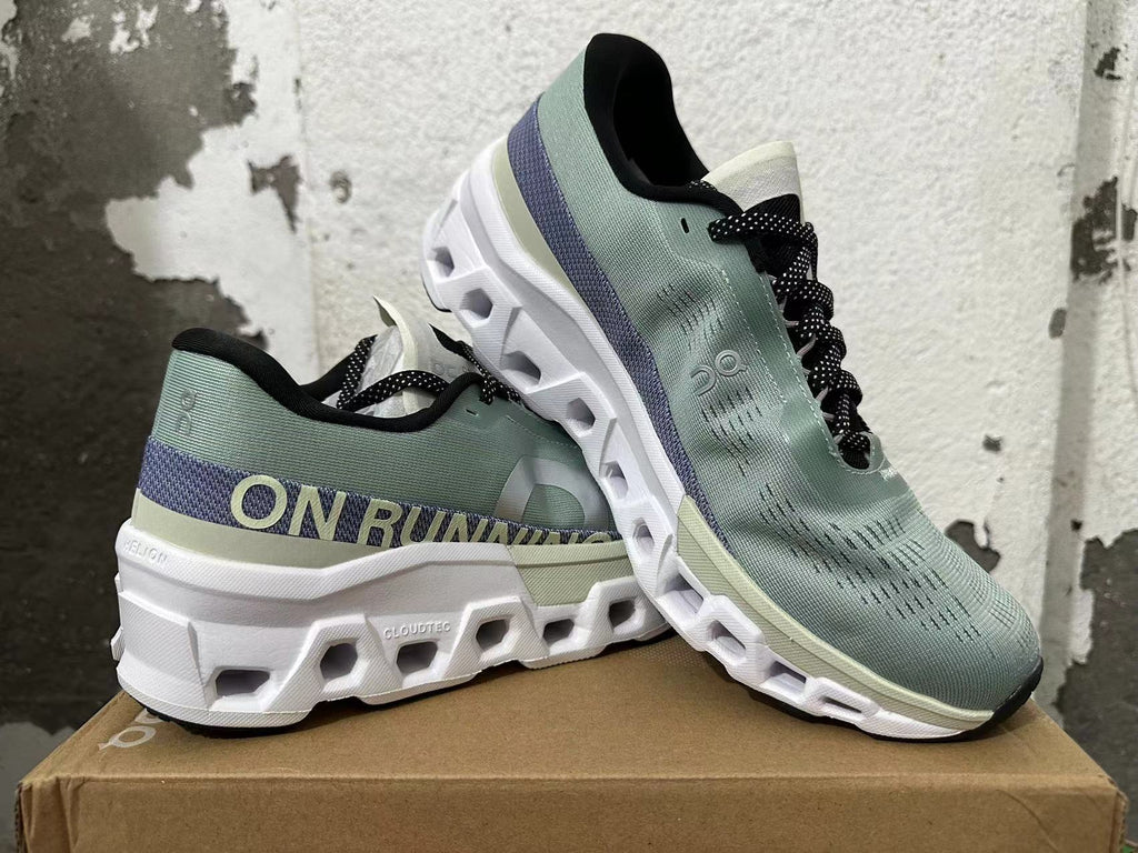 Pair of sage-green On Running shoes shown at an angle, highlighting the upper and sculpted sole.