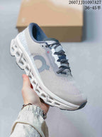 Angled side view of the sneaker showing On branding, gray detailing, and the sculpted white sole.