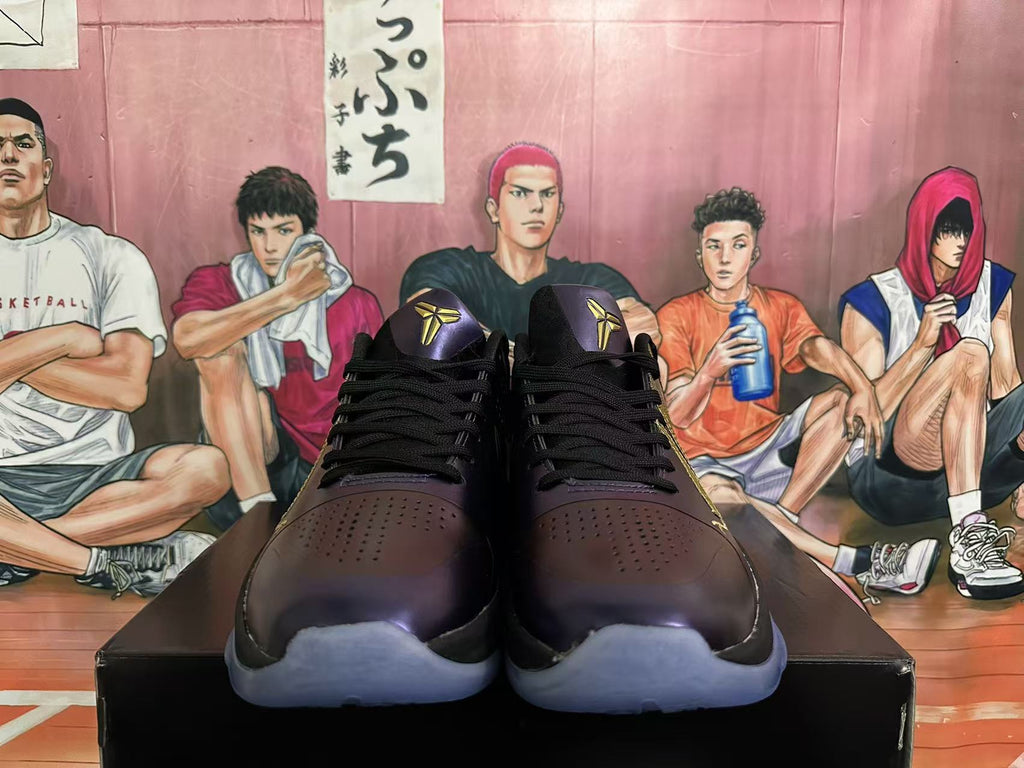 Front view of black and purple Nike basketball shoes with gold Kobe logos
