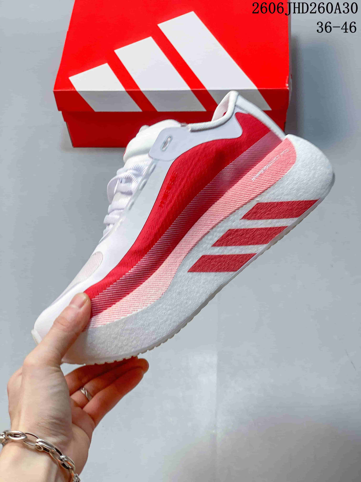 Side view of the red and white running shoe with a sculpted sole