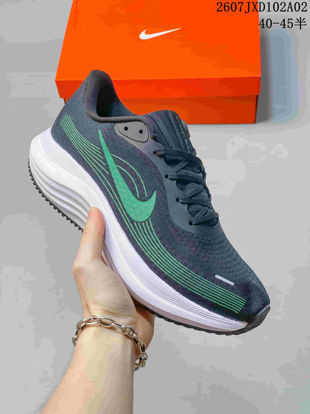 Close-up of a charcoal running shoe with teal side graphics and a white midsole