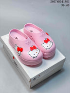 Pair of pink Hello Kitty platform mule clogs with red bow details.
