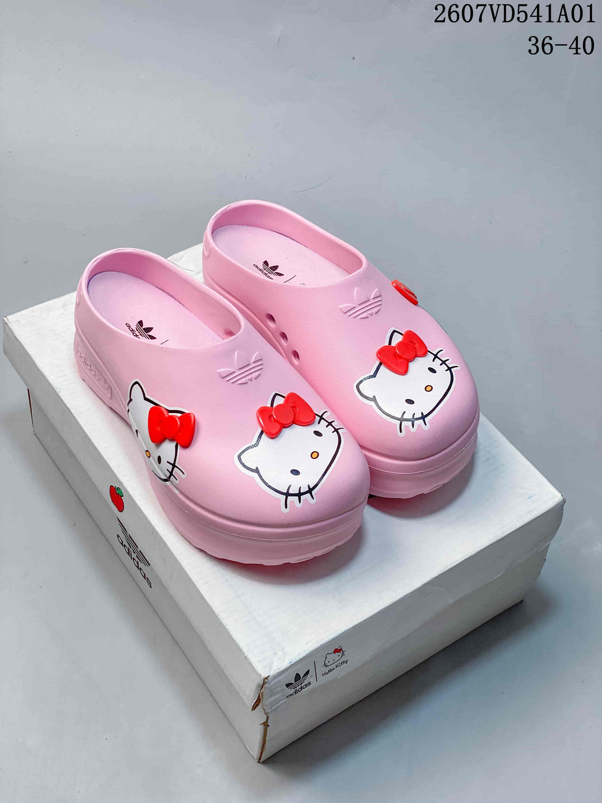 Pair of pink Hello Kitty platform mule clogs with red bow details.