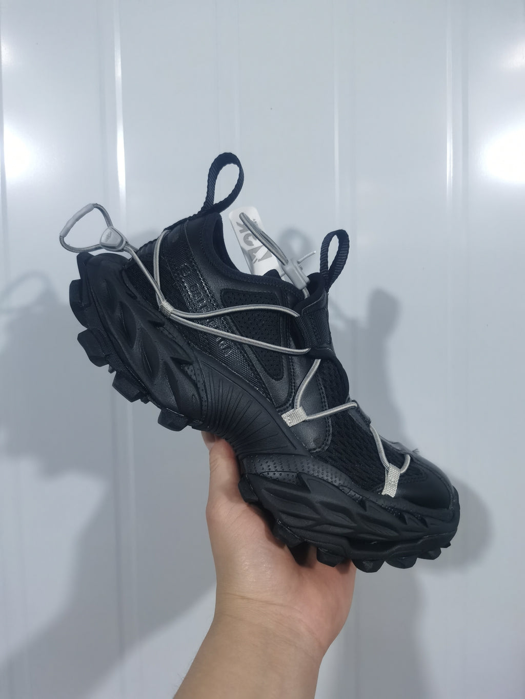 Side view of the black Nike sneaker highlighting the textured upper, sculpted midsole, and rugged outsole.