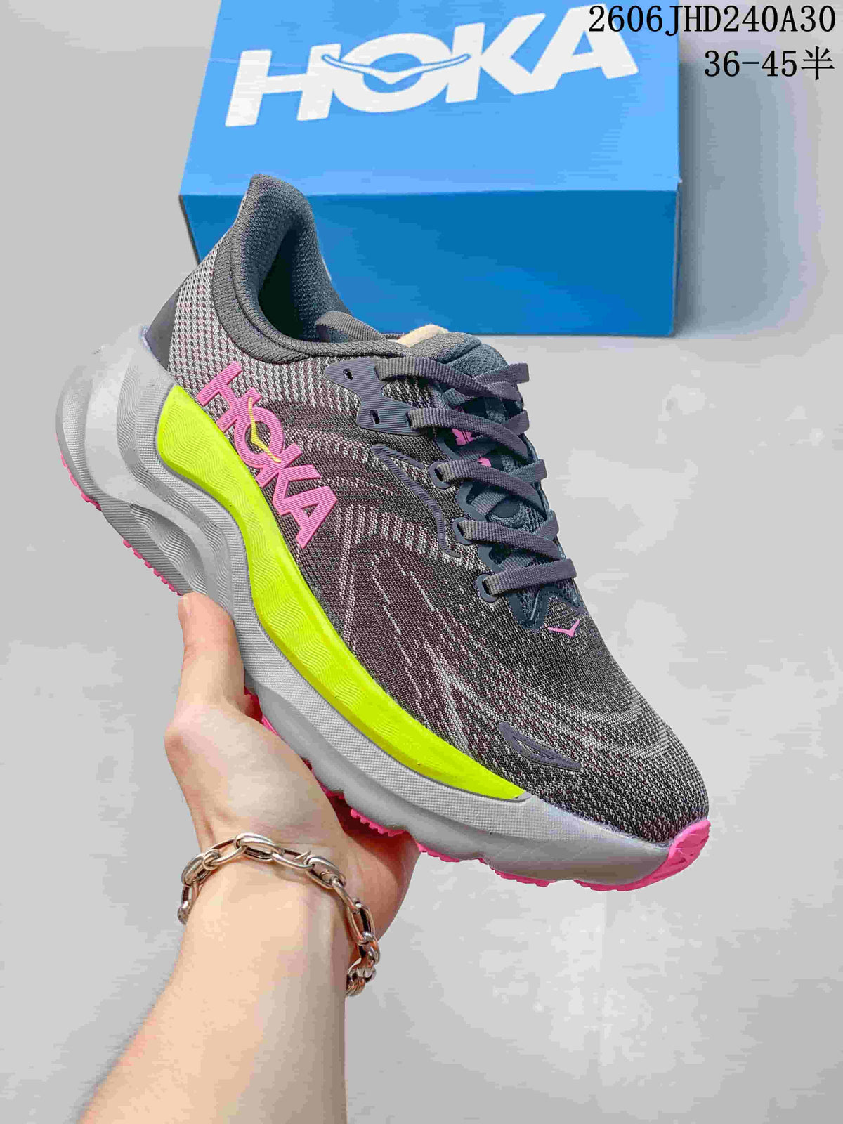 Gray HOKA Arahi 8 running shoe with pink and bright yellow-green accents.