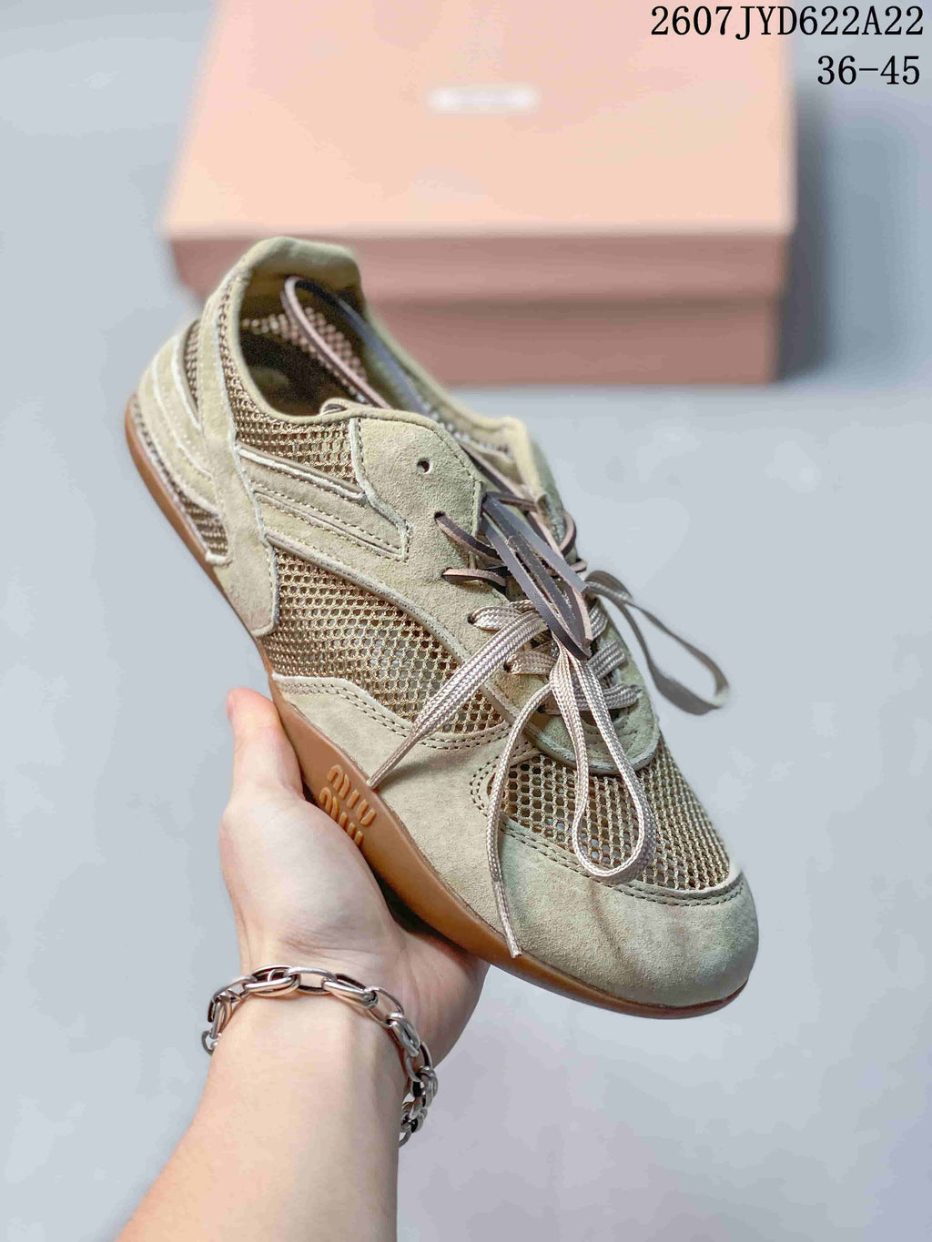 Angled side view of the beige Miu Miu sneaker showing mesh panels, layered construction, contrasting laces, and gum-tone outsole; image text shows 2607TYD622A22 and 36–45.