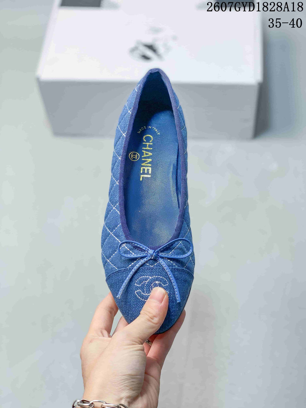 Top view of the blue ballet flat showing the bow, quilted pattern, toe logo detail, and branded insole.