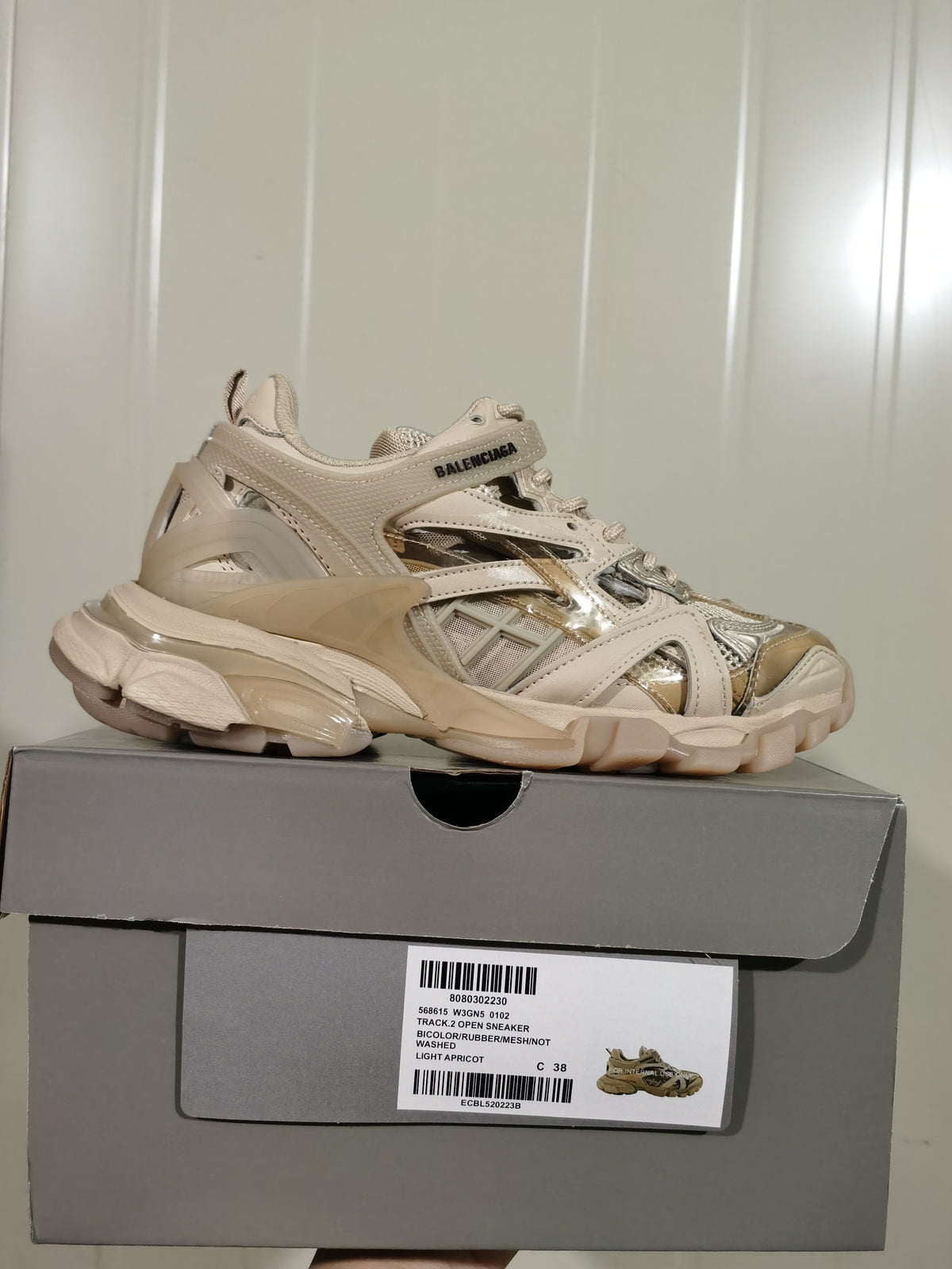 Side view of the light apricot sneaker on a shoe box; the upper visibly reads BALENCIAGA and the box label shows a photographed size of C 38.
