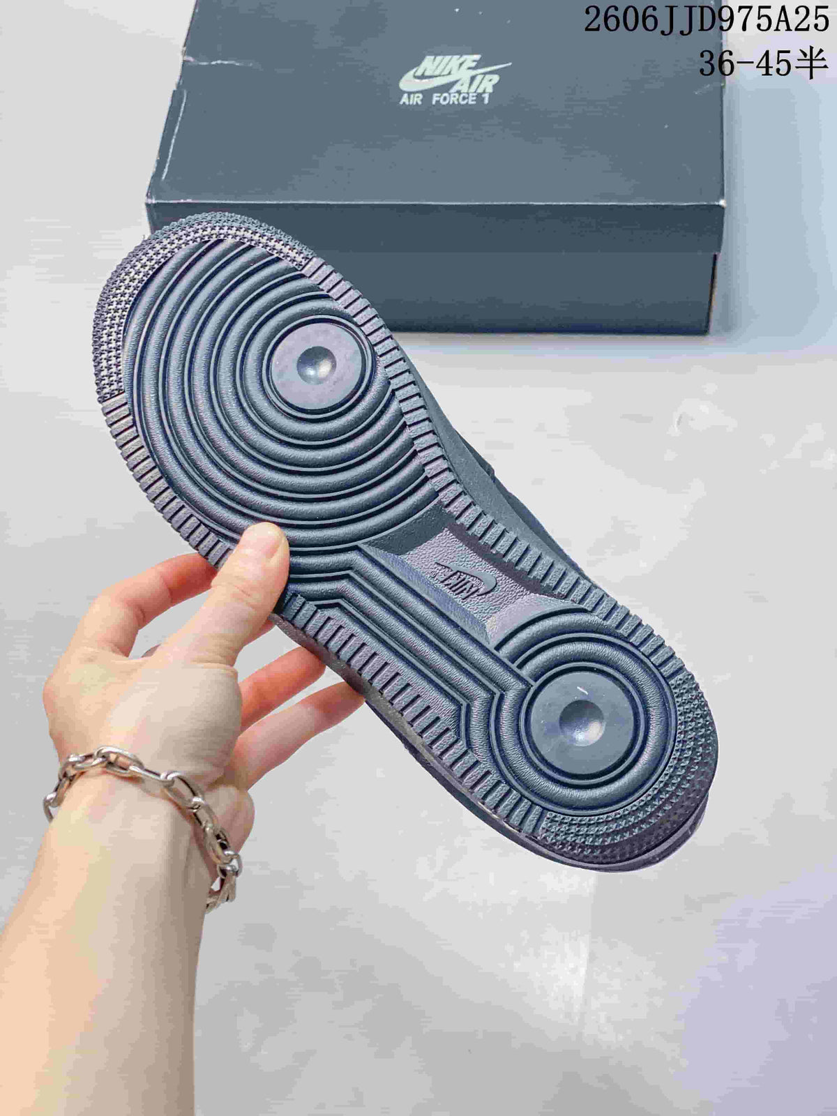 Close-up of the black sneaker outsole showing concentric circular traction grooves and a textured perimeter.