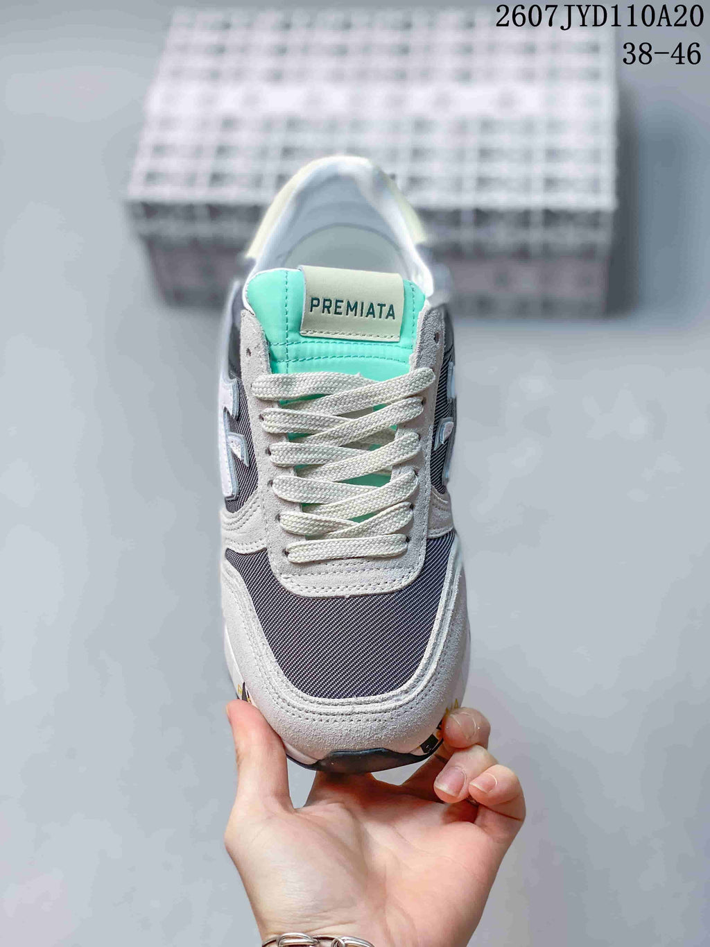 Front view of a Premiata sneaker with grey overlays, a navy textile toe area, white laces and a mint-green tongue; image text shows 2607 TYD110A20 and 38–46.