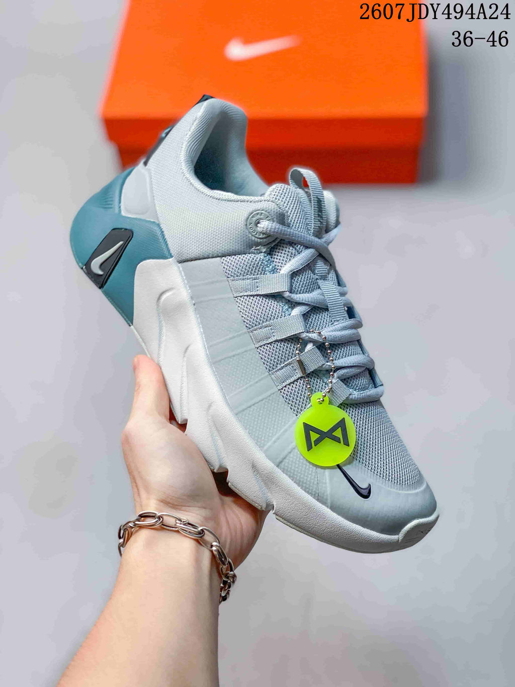 Angled side view showing the light gray upper, blue heel detail, and black Nike branding.
