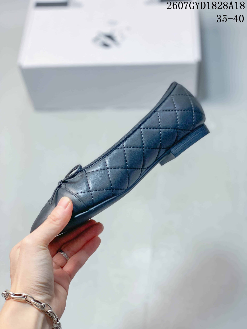 Side profile of a black quilted ballet flat showing the flat sole and low heel.
