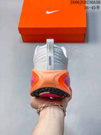 Rear view of the shoe showing its white heel and orange and pink midsole details.