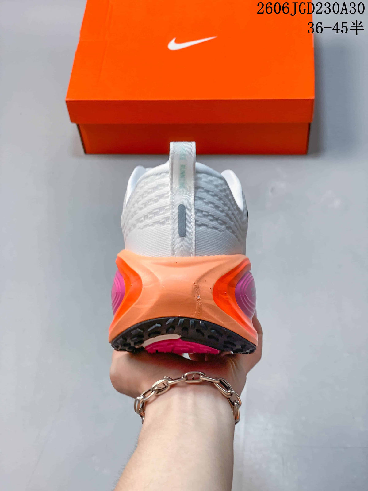Rear view of the shoe showing its white heel and orange and pink midsole details.