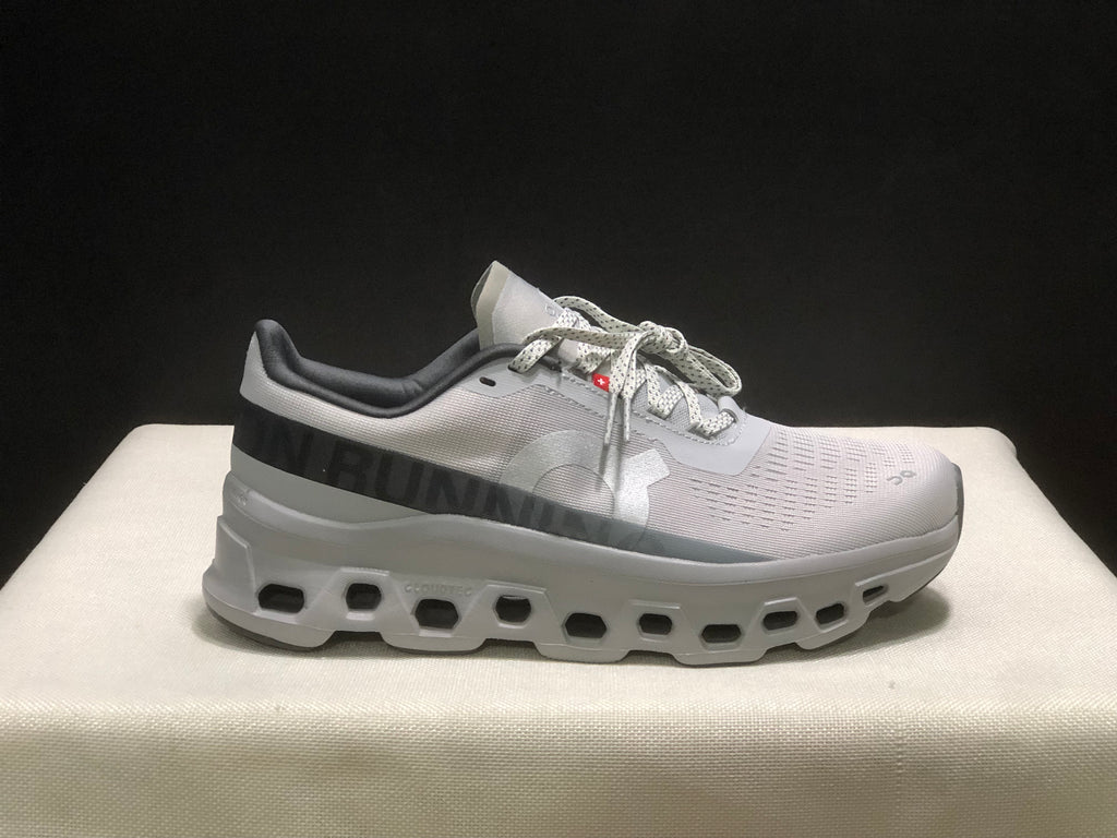 Side profile of the sneaker showing On branding, patterned upper panels, and the chunky cutout-style outsole.