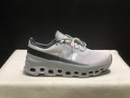 Side profile of the sneaker showing On branding, patterned upper panels, and the chunky cutout-style outsole.