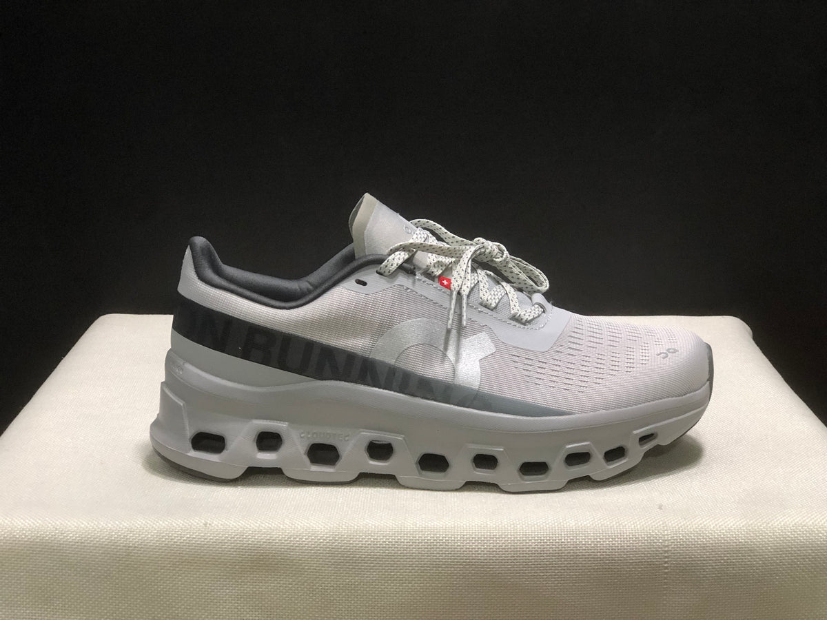 Side profile of the sneaker showing On branding, patterned upper panels, and the chunky cutout-style outsole.
