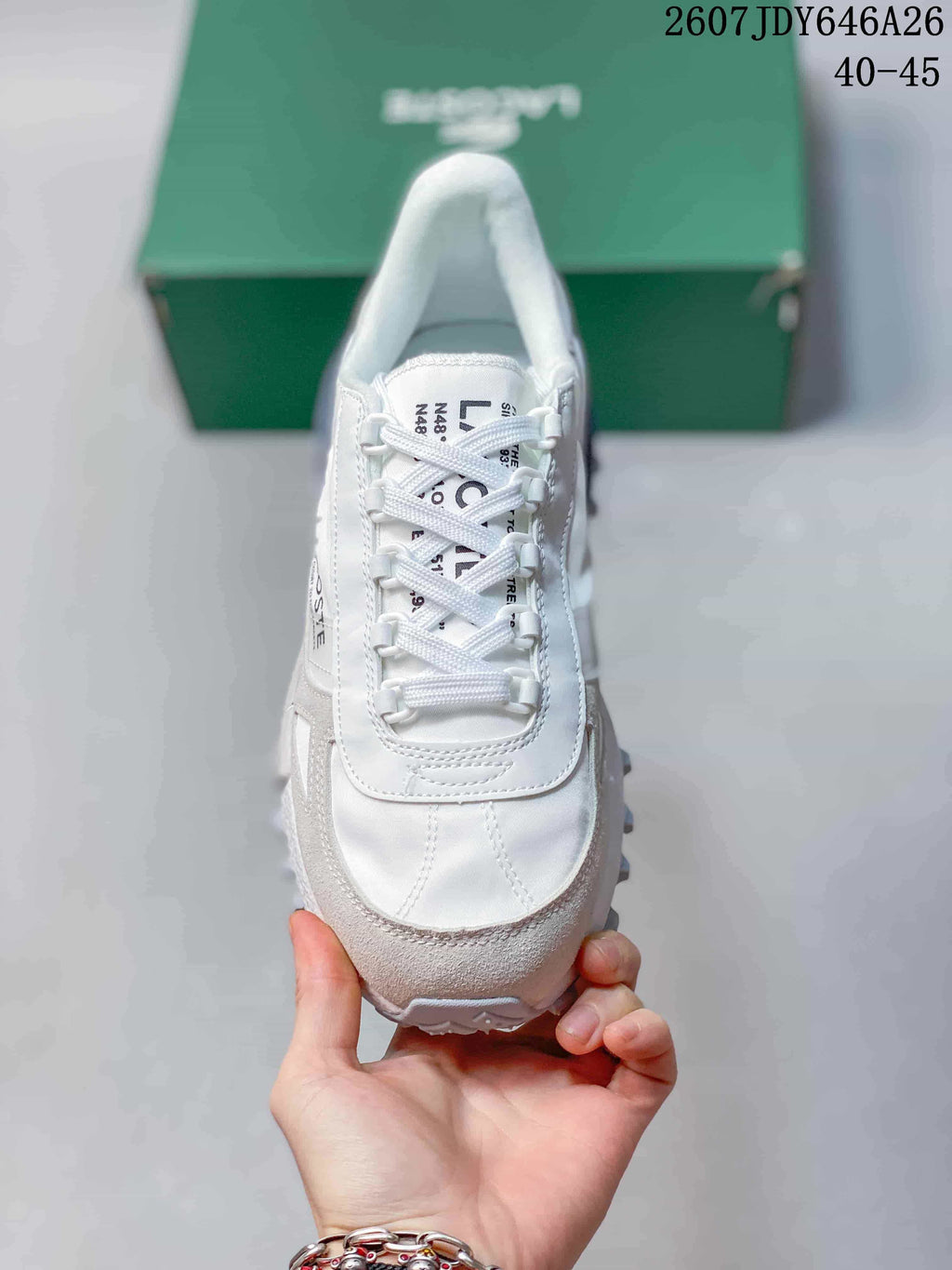 Top view of the white and gray sneaker showing the rounded toe, white laces, stitched panels, and tongue branding.