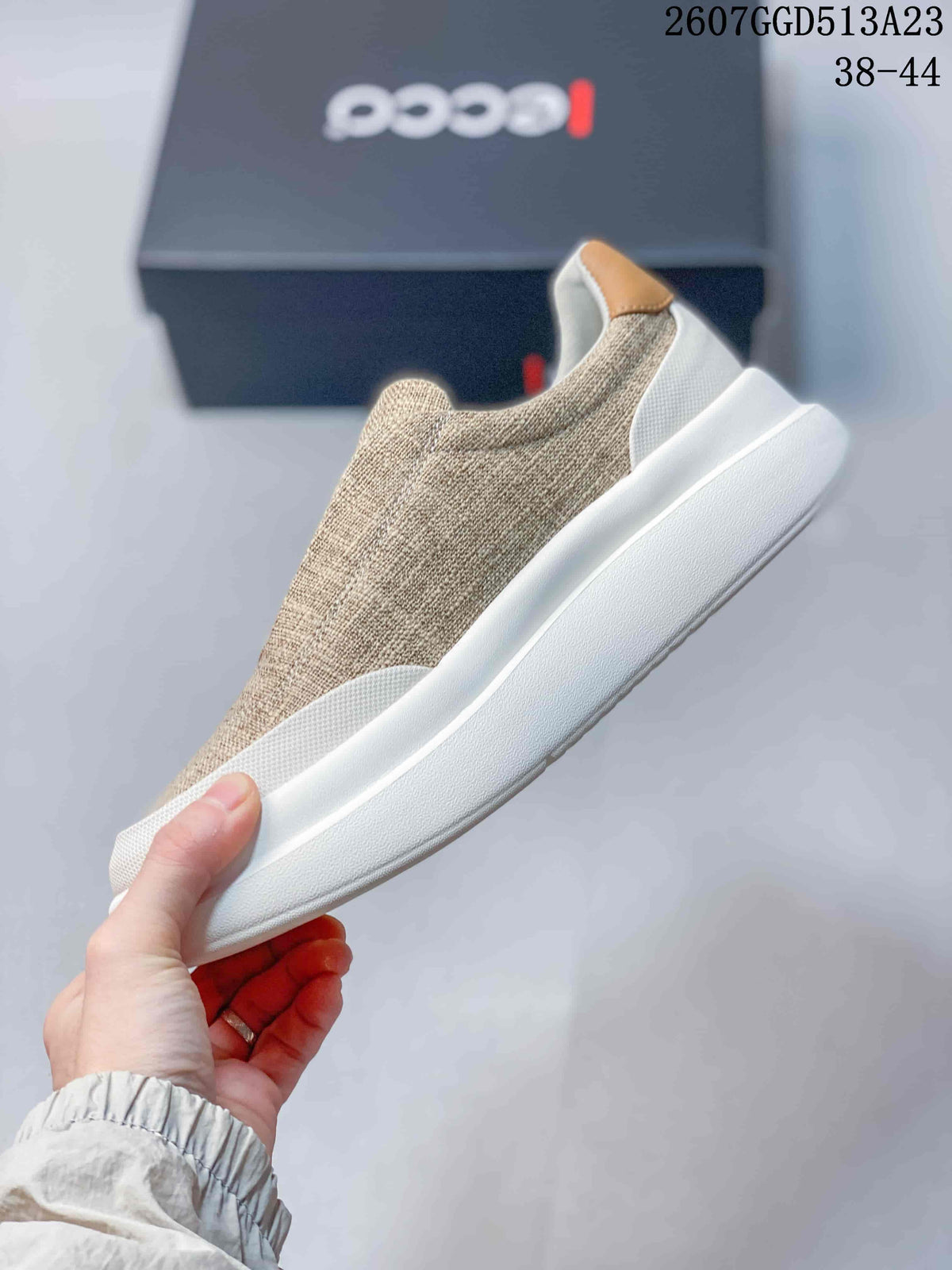 Side view of a beige ECCO sneaker showing the textured upper, tan heel accent, and thick white outsole.