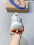 Rear view of the white running shoe showing the heel pull tab, raised sole, and yellow outsole accents.