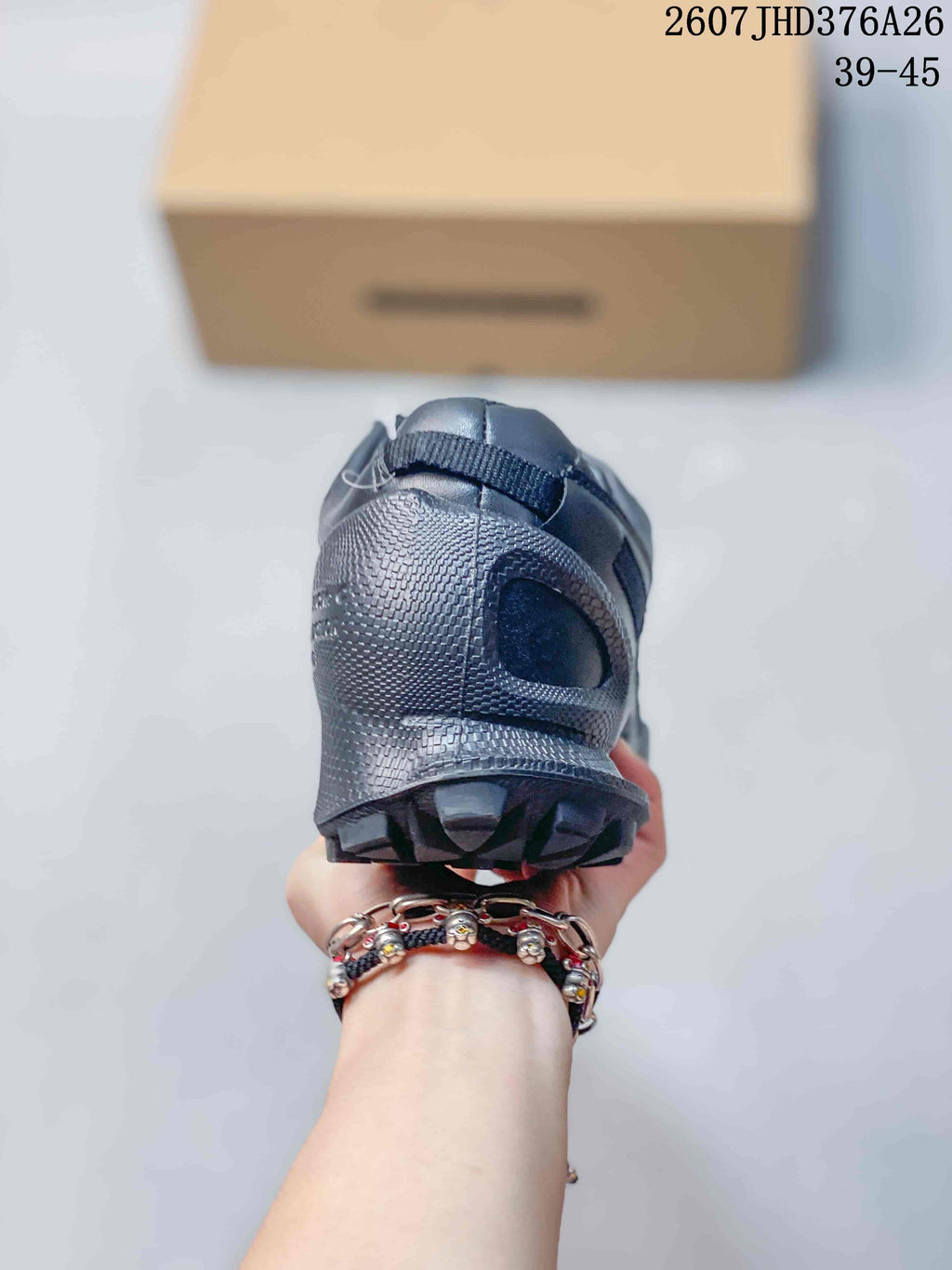 Rear view of a black sneaker showing the padded heel area and rugged outsole edge.