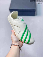 Angled side view showing the off-white upper, curved side panel, green stripes, and rounded toe.