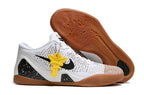 White shoe with a gum-colored outsole and yellow hanging accent.