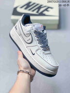 Close-up of a white low-top sneaker showing layered side panels, a dark swoosh, patterned laces, perforations, and Air branding.