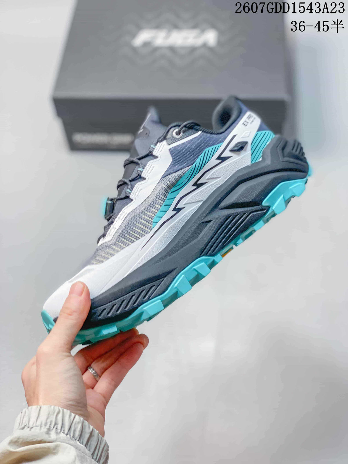 Side profile of the gray, white and teal Kailas trail running shoe showing the layered upper and rugged outsole.