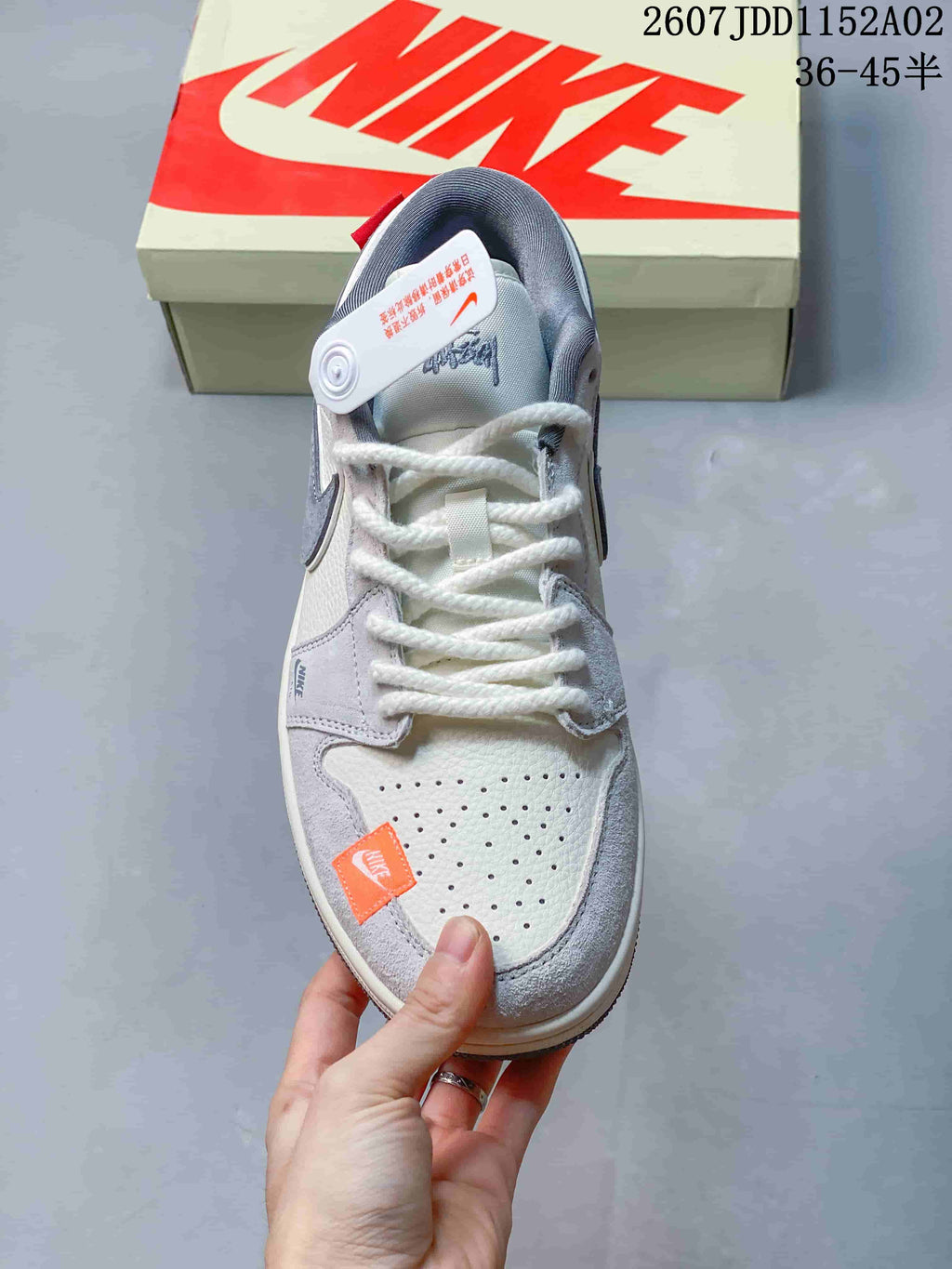Top view showing the perforated toe, white laces, gray overlays, and orange accent label.