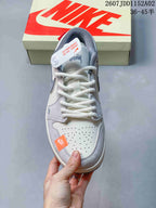 Top view showing the perforated toe, white laces, gray overlays, and orange accent label.
