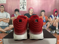 Rear view of red and white Nike sneakers showing the heels and light-colored midsoles