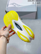 Underside of a Saucony Endorphin Pro shoe showing a white sole with bright yellow traction sections.