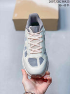 Top view of the sneaker showing the laces, tongue branding, and gray upper panels.