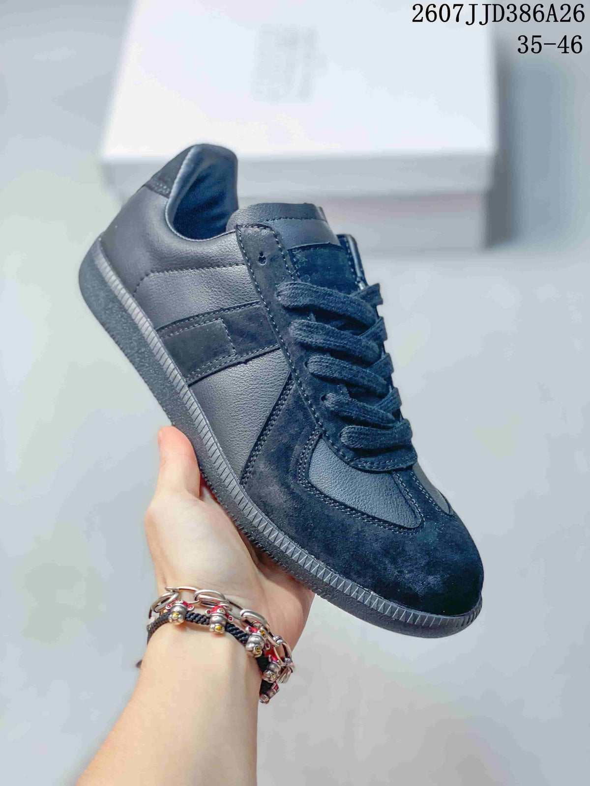 Angled side view of the black low-top sneaker showing the lace-up construction, layered side panels, padded collar, and textured outsole.