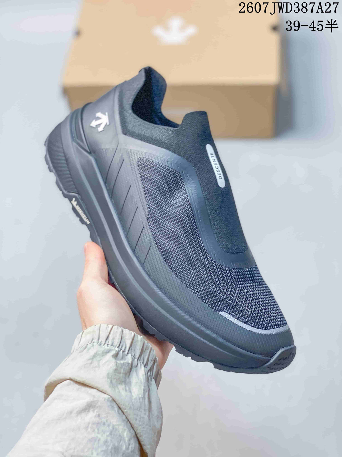 Angled side view of the dark gray DESCENTE slip-on sneaker with textured panels and a rugged outsole.