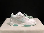 Close side profile of a white low-top sneaker with pale mint side branding accents and outsole inserts.