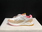 Lateral side view showing the beige overlays, textured white panels, pink collar and layered sole.