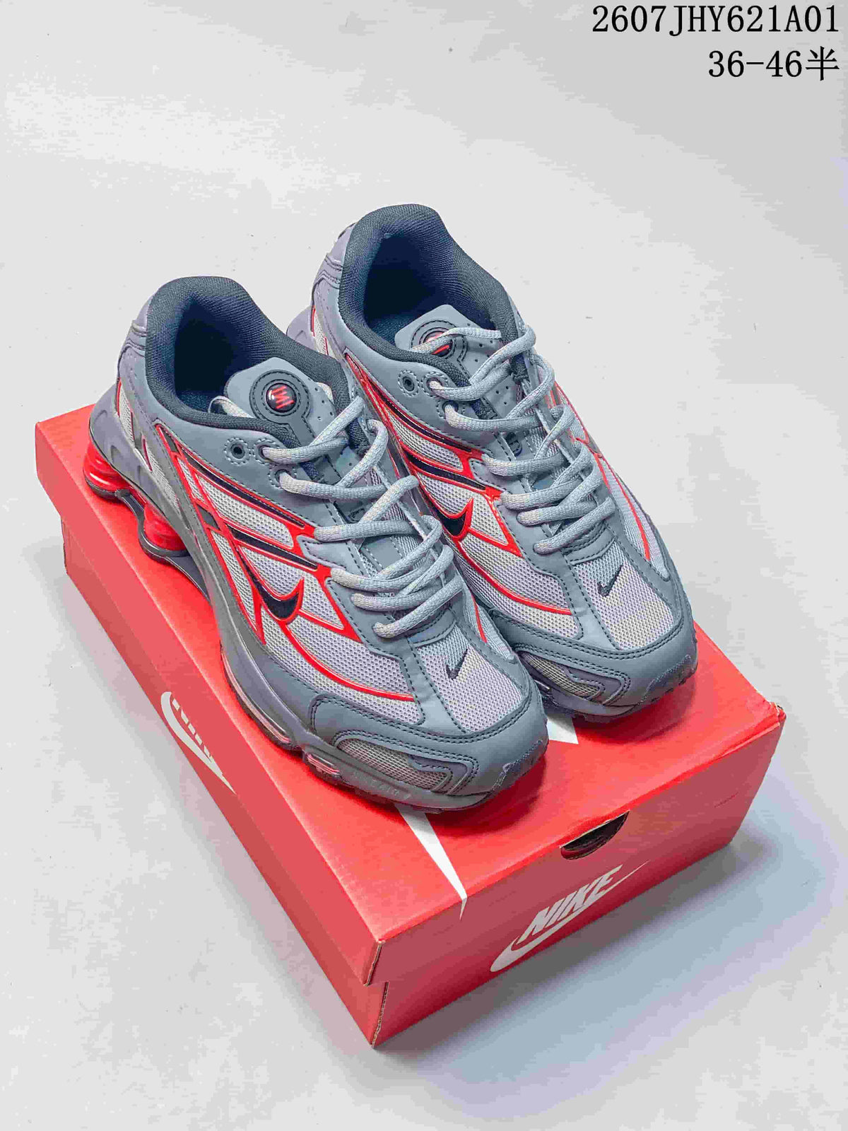 Pair of grey and red Nike Shox Ride 2 sneakers on a red shoe box