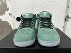 Front view of green Nike Kobe basketball shoes with black laces and perforated toe panels.