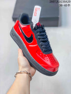 Angled side view showing the glossy red upper, black Swoosh, black laces, and black sole; image text shows style code 2607TGD230A20 and size range 36–45 with half sizes.