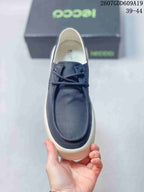 Top view of the sneaker showing the rounded moc-toe design, laces, and navy upper.