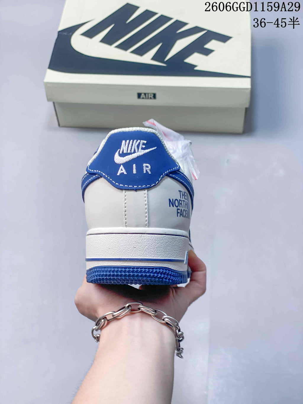 Rear view of the sneaker showing blue heel tab, white heel panel, and visible branding.