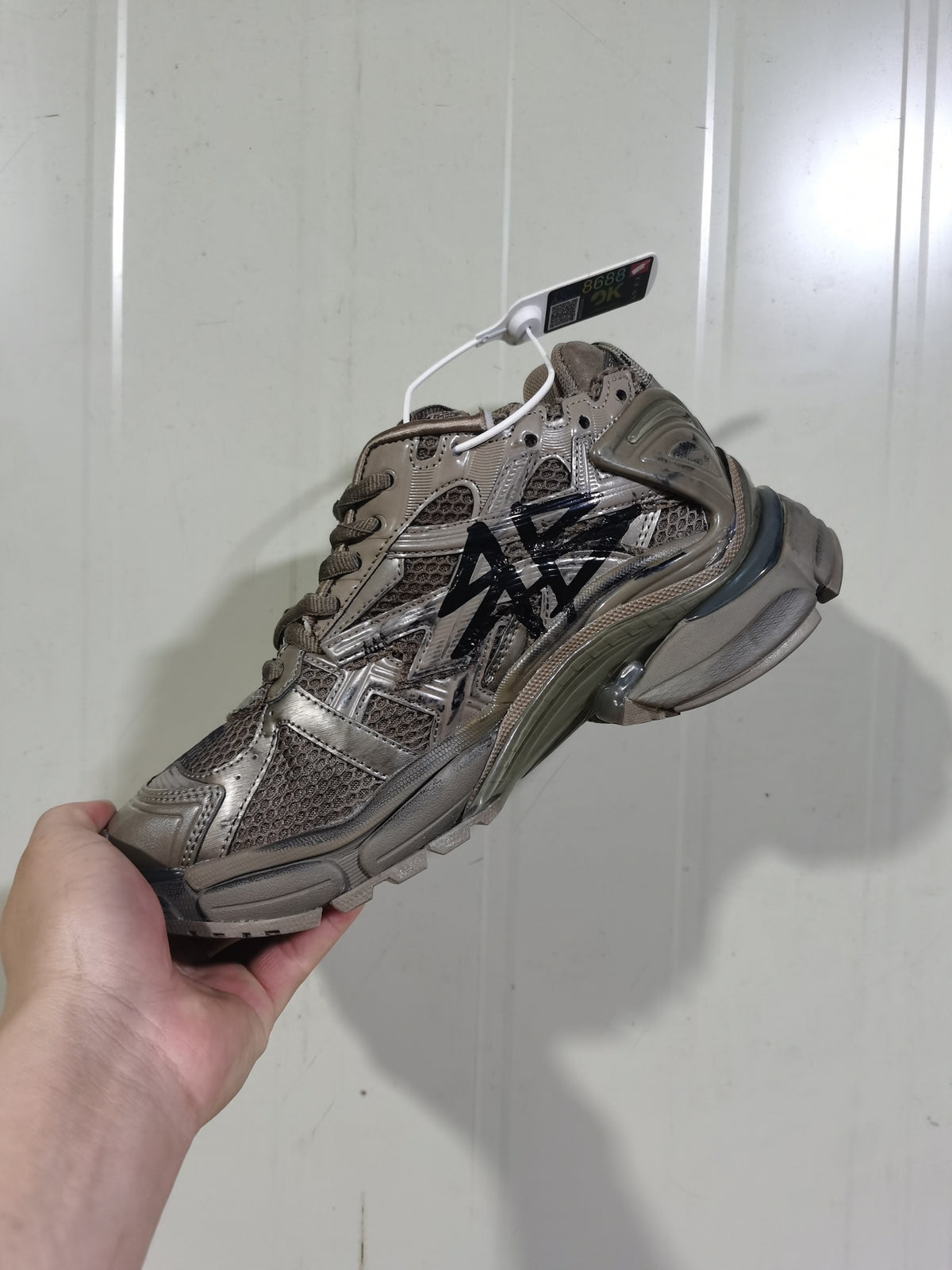 Opposite angled view of the dark taupe and black Balenciaga Runner 2010 sneaker, showing the mesh upper and sculpted outsole.
