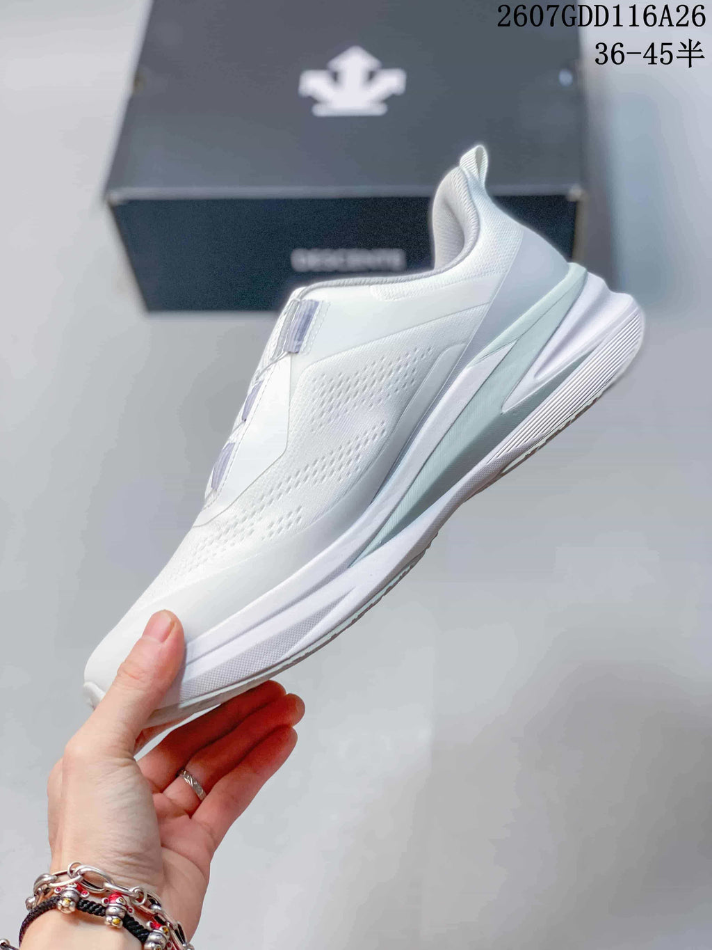 Side profile of the white low-top sneaker showing the perforated-looking upper panels and raised heel.