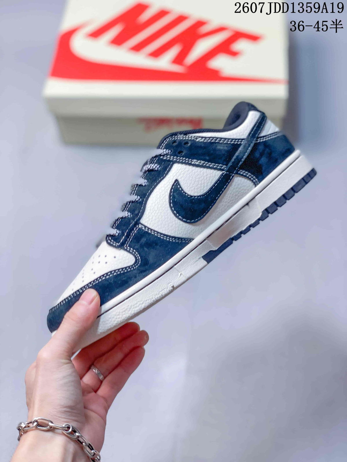Side view highlighting the navy overlays, white mid-panel, Swoosh branding, and layered sole.
