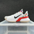 Side view of a white Nike basketball shoe with a black Swoosh, red midsole accents, and multicolor heel details.