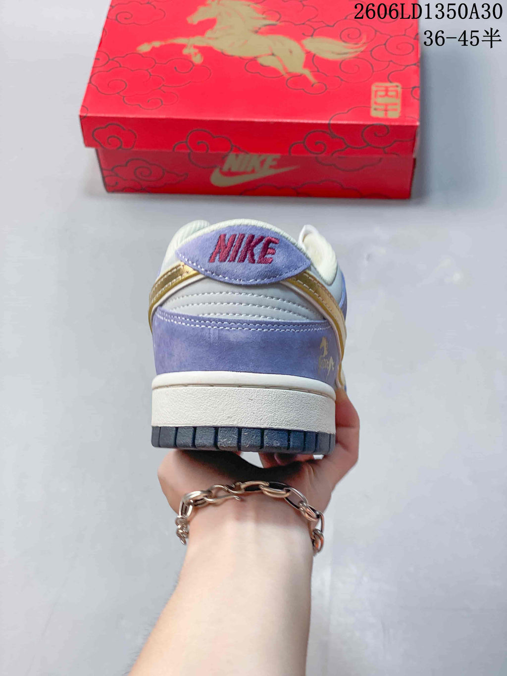 Rear view of the lavender Nike SB Dunk Low with contrasting heel panels and a red horse-themed box.