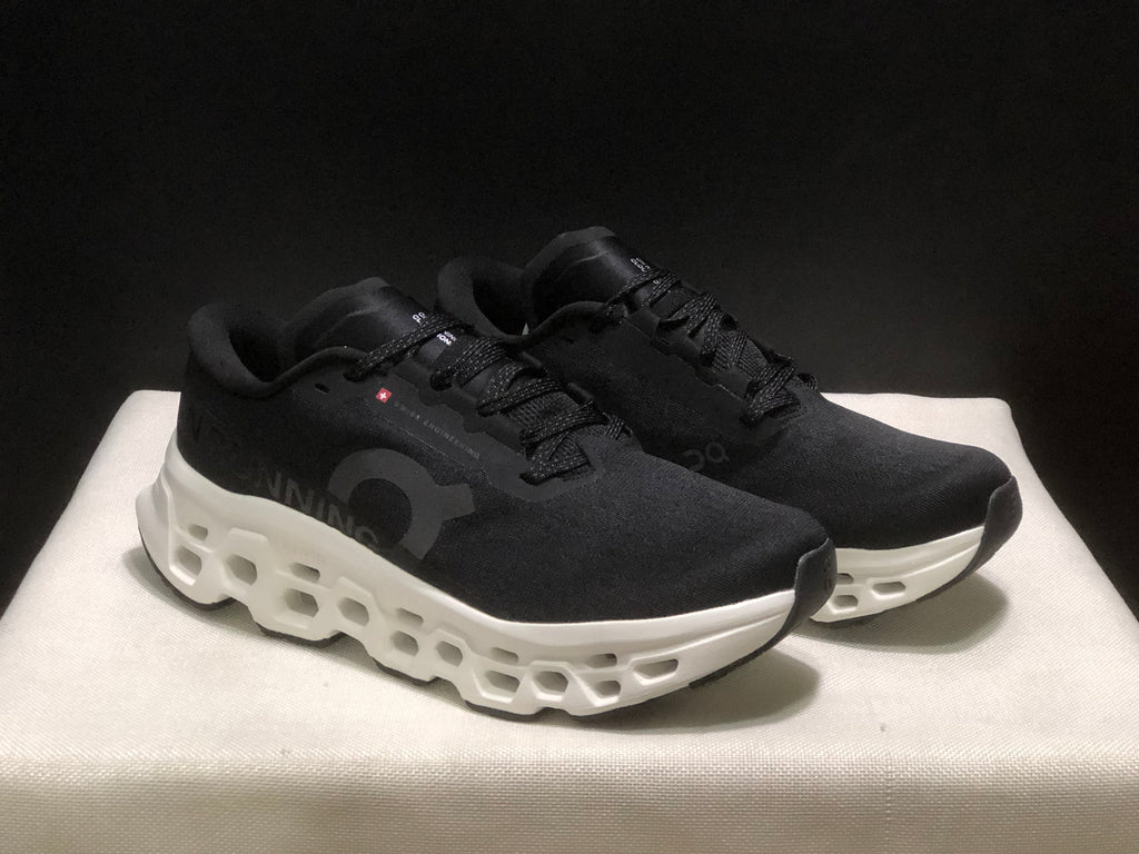 Three-quarter view of the black and white running sneakers with lace-up uppers and sculpted midsoles.