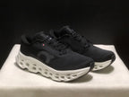 Three-quarter view of the black and white running sneakers with lace-up uppers and sculpted midsoles.